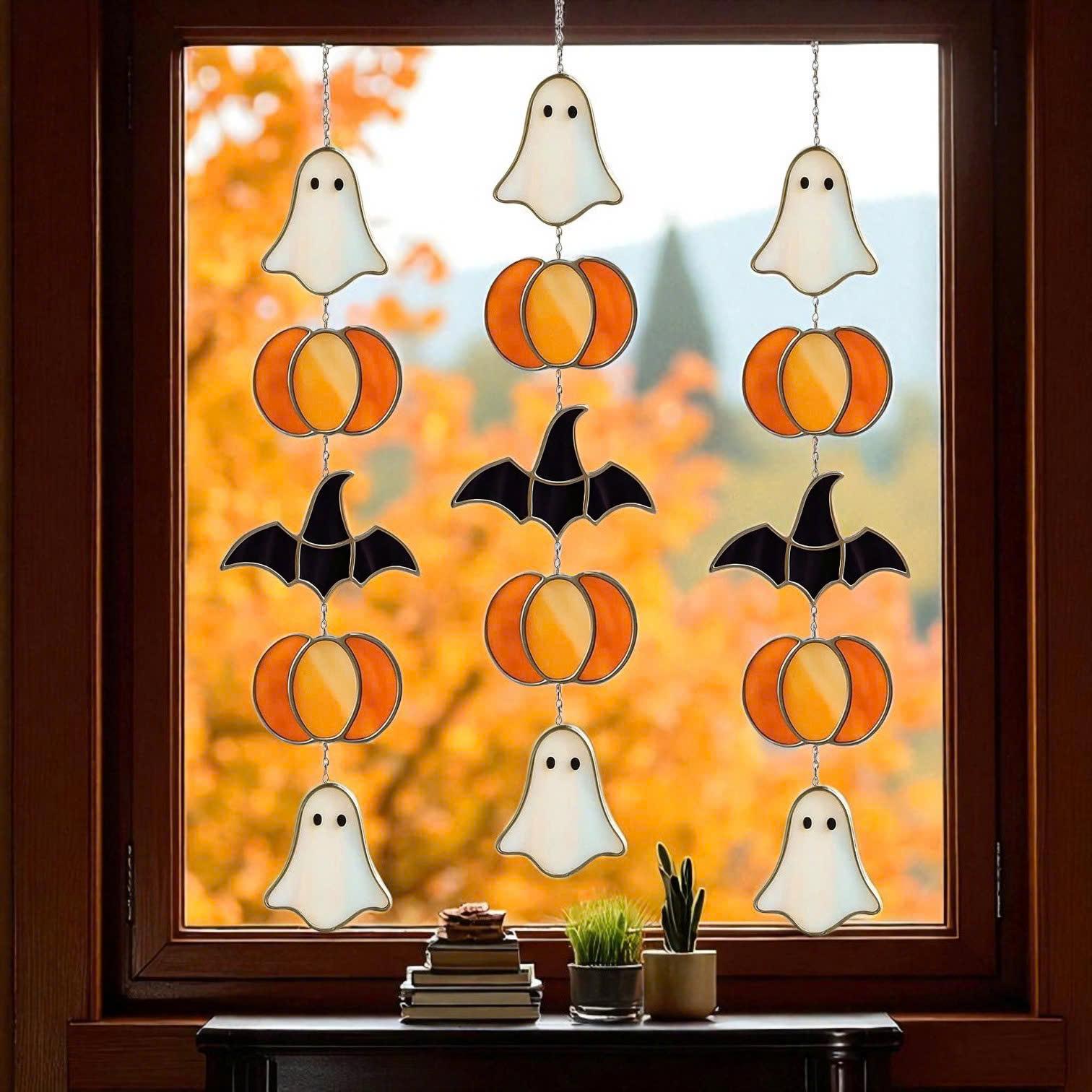 Handmade stained glass Halloween suncatcher featuring cute ghosts with witch hats and orange pumpkins, window hanging decoration