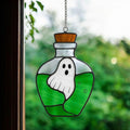 Handcrafted stained glass suncatcher featuring a ghost inside a purple potion bottle, real glass cut and soldered by hand, sunlight shining through for magical Halloween window decor.