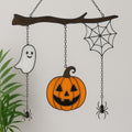 Handmade stained glass ghost pumpkin and spiderweb suncatcher on plain white background.