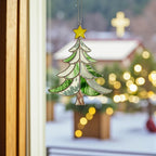 Stained glass tree ornament Style #3 hanging in a window with a blurred outdoor background, focusing on product detail.