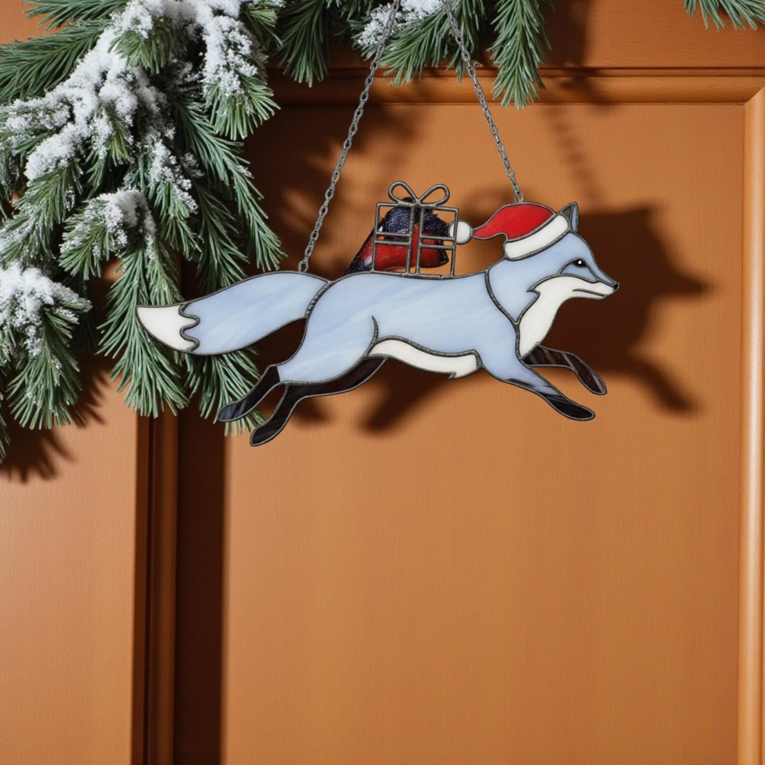Blue stained glass fox with Santa hat carrying gift, handmade Christmas suncatcher.