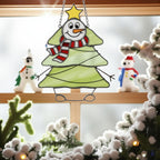 Snowman stained glass suncatcher under snowy Christmas decorations, festive window art.