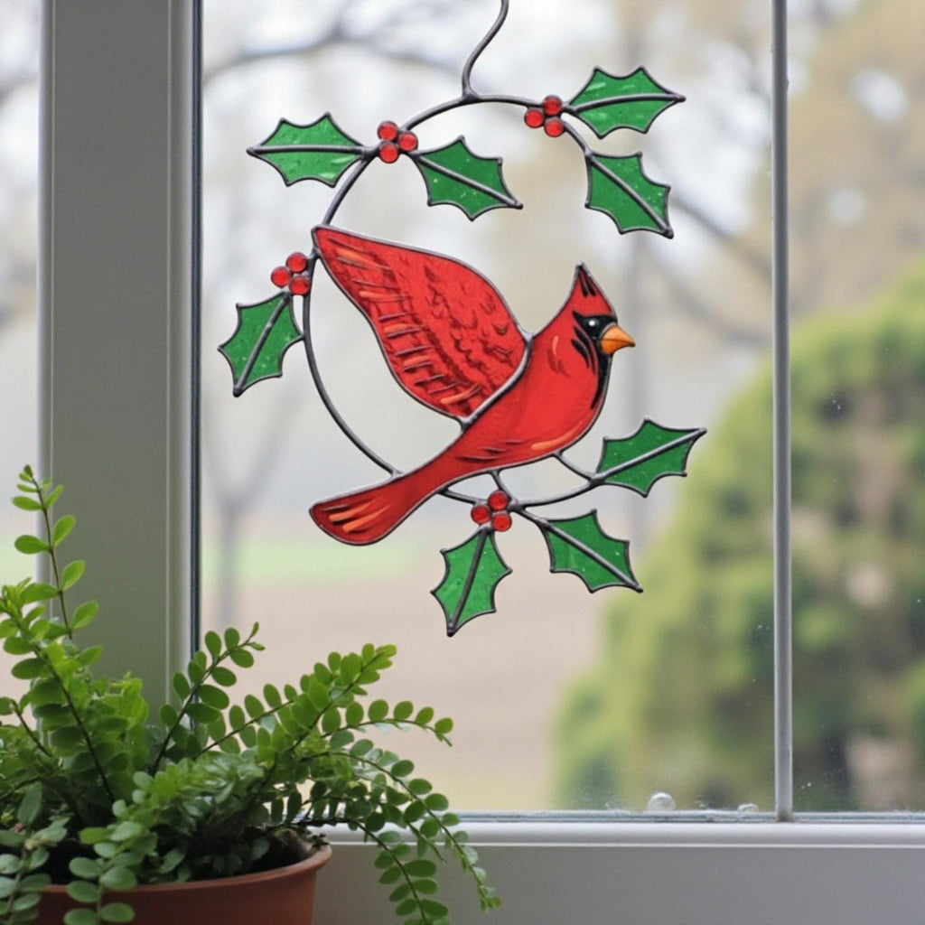 Red cardinal glass suncatcher surrounded by plants – nature inspired handmade glass art decor.