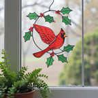 Red cardinal glass suncatcher surrounded by plants – nature inspired handmade glass art decor.