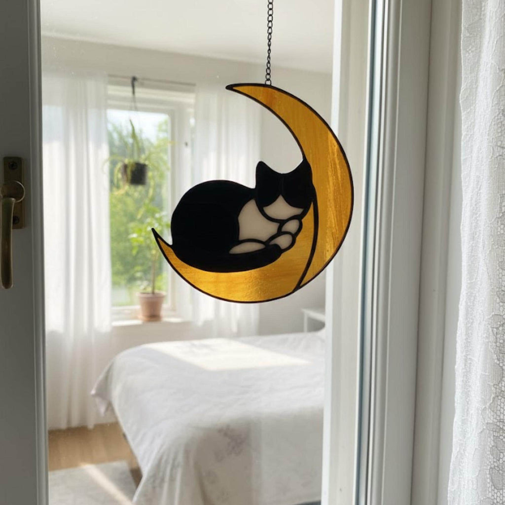 Woman hanging cat on the moon stained glass suncatcher on window, handmade glass decor