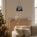 Detailed shot of stained glass winter cottage with golden sun and snow, handmade Christmas suncatcher.