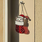 Handmade stained glass cat ornament glowing beside potted plant, cozy holiday home decor.