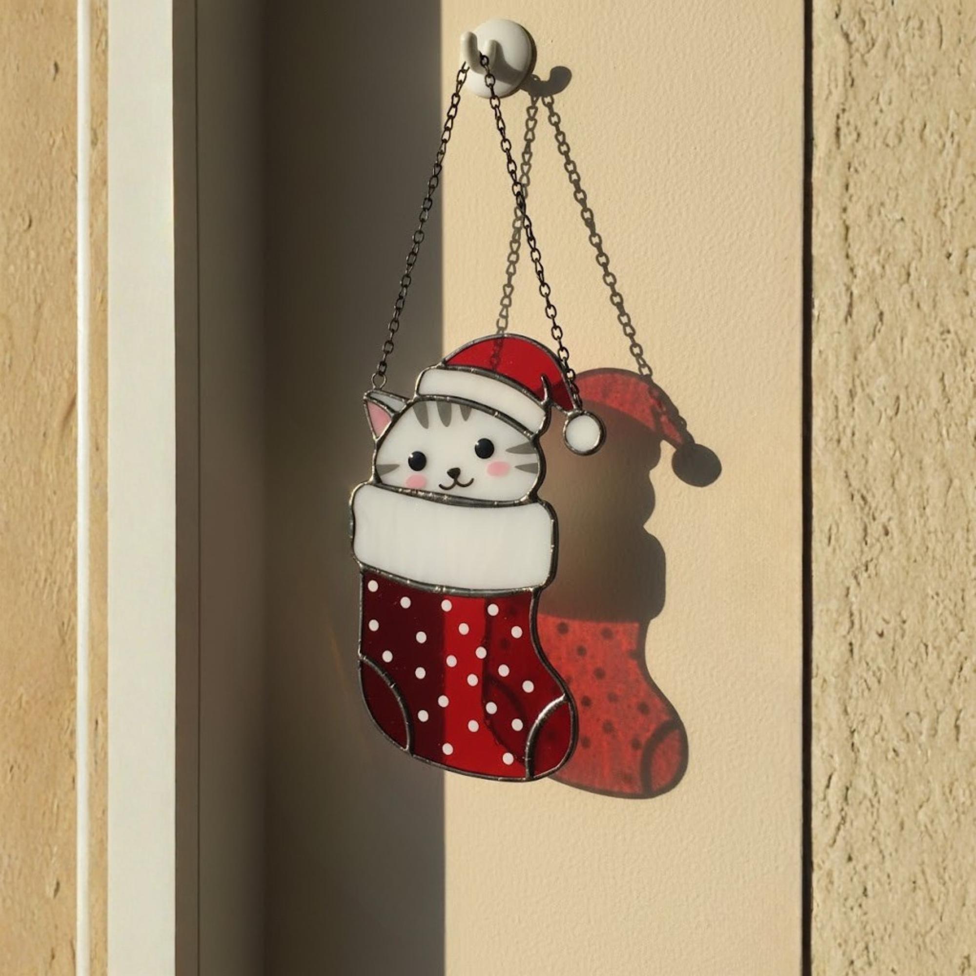 Handmade stained glass cat ornament glowing beside potted plant, cozy holiday home decor.