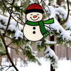 Snowman ornament (Style #1) hanging outdoors with a blurred snowy background, highlighting the blue and pink glass.