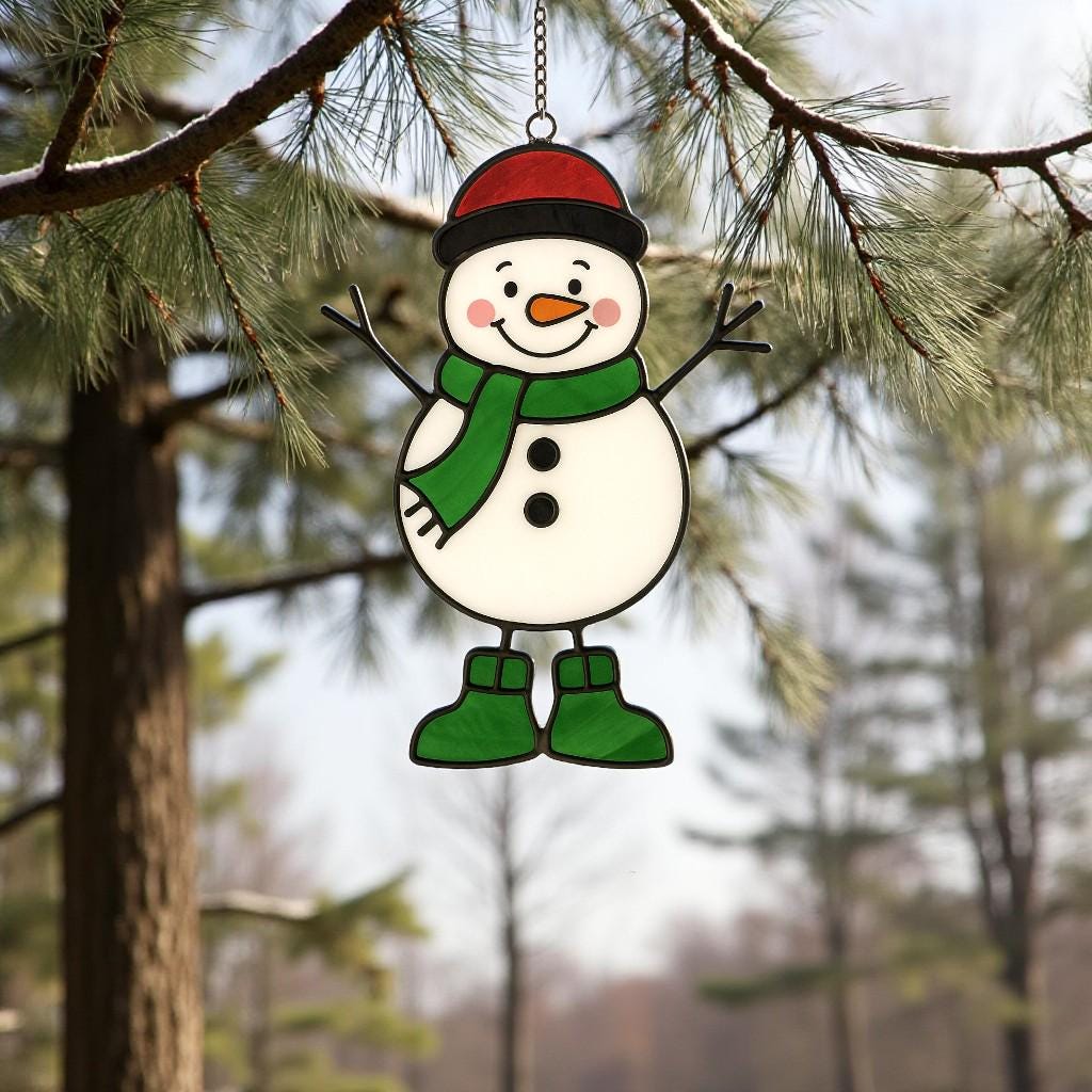 Snowman ornament (Style #3) hanging in a window with a blurred outdoor tree and house background.