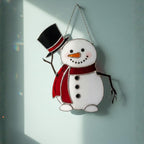 Holiday glass snowman ornament catching light – winter window decor handmade art.