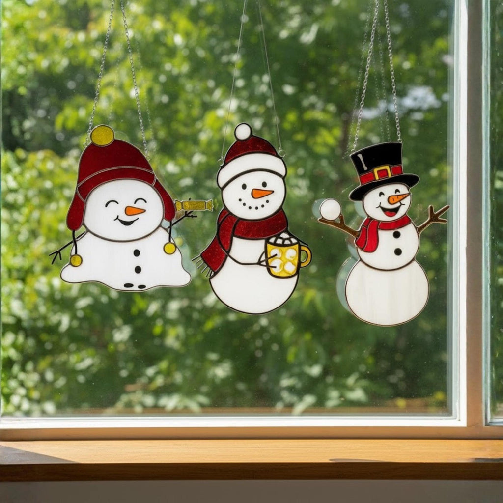 Snowmen glass ornaments shining in sunlight – unique handmade Christmas decor.