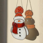 Classic white snowman glass ornament in sunlight – handmade window decoration.