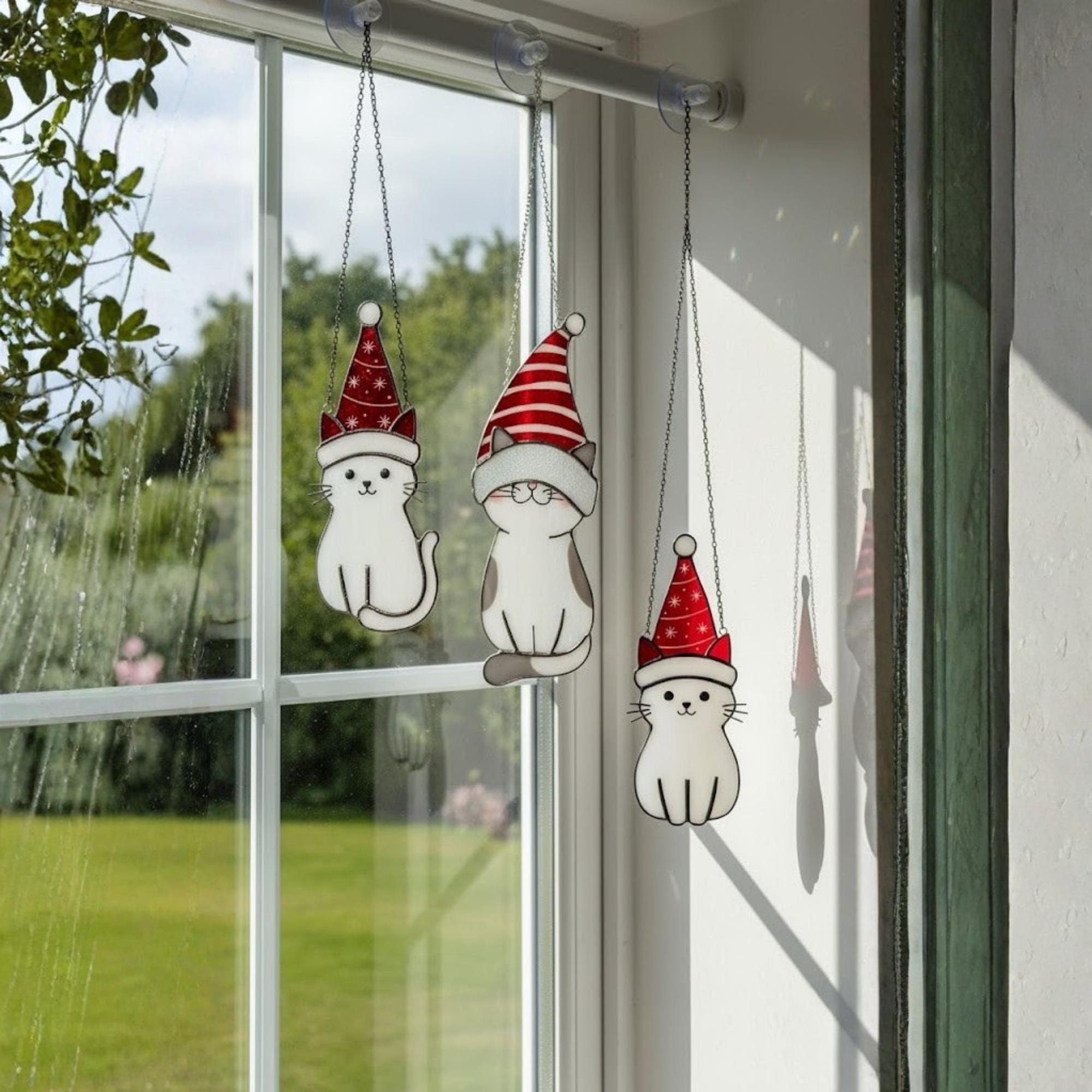 Handmade stained glass cat ornament hanging by sunny window – cozy handmade home decor gift idea.