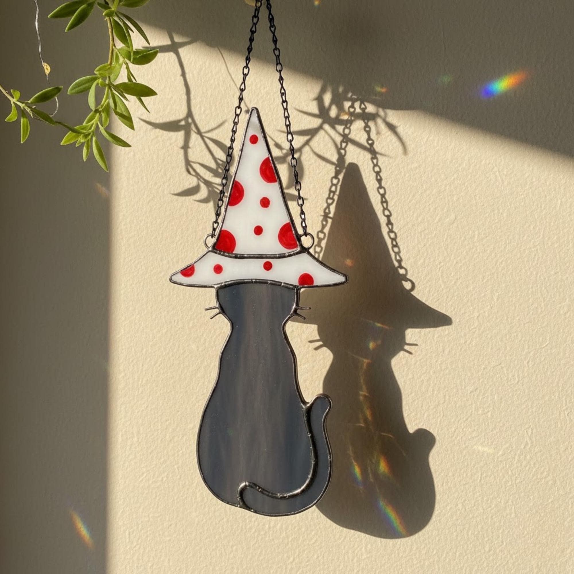 Set of black cat and white cat stained glass ornaments on wall – handmade window hanging decor.