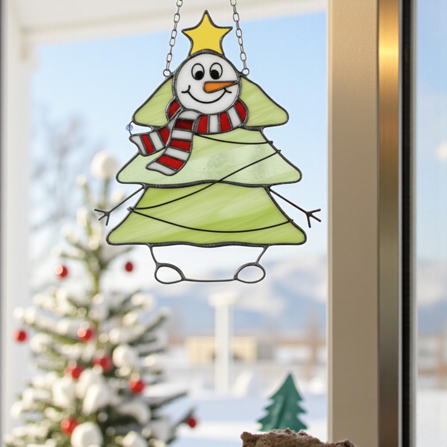 Handmade stained glass snowman Christmas tree ornament hanging on window, festive holiday decor.