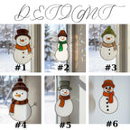 Trio of snowman ornaments hanging on snowy pine tree – outdoor Christmas stained glass decoration.