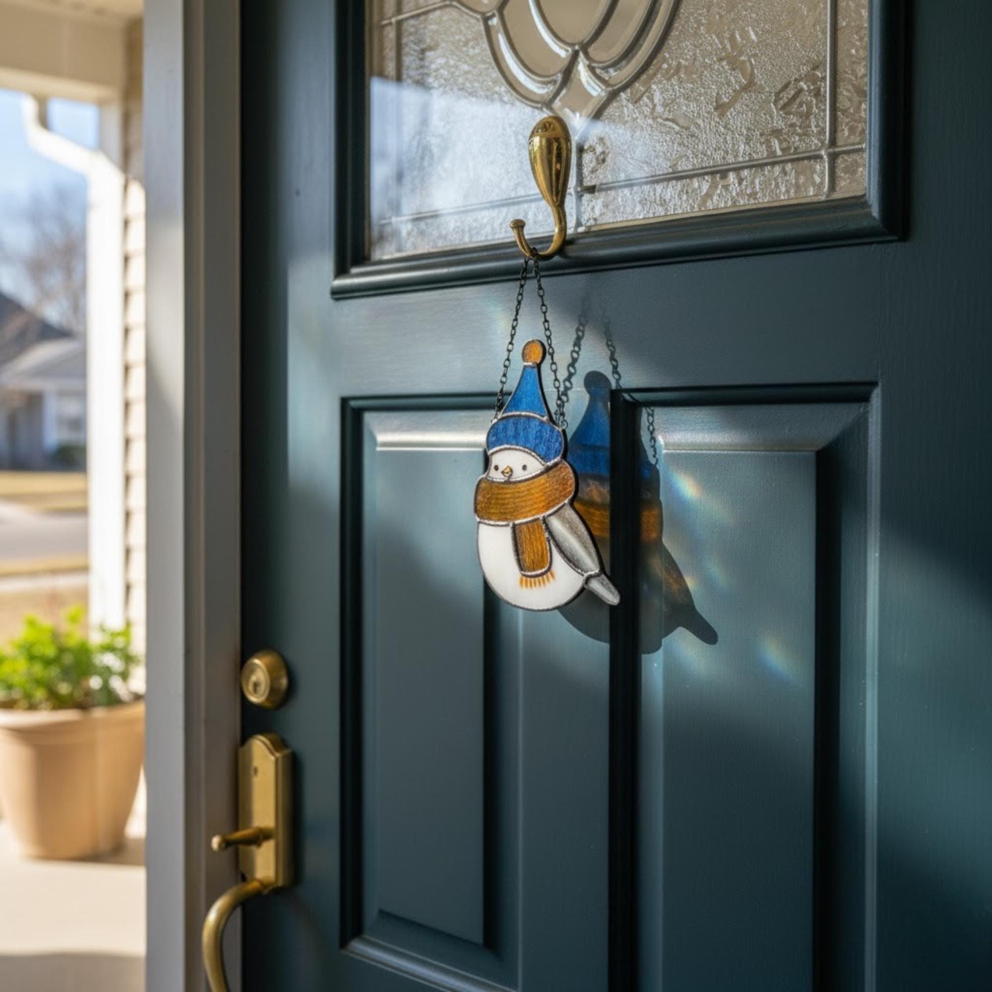 Colorful bird ornaments hanging by window sunlight – handmade stained glass winter decor.