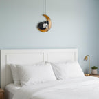 Cat on the moon stained glass window ornament glowing in afternoon sunlight, artistic home accent