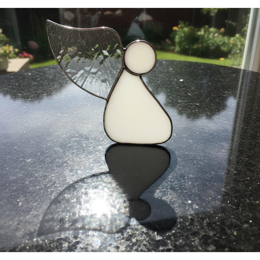 Guardian angel ornament hanging in bright home interior symbolizing peace and love.