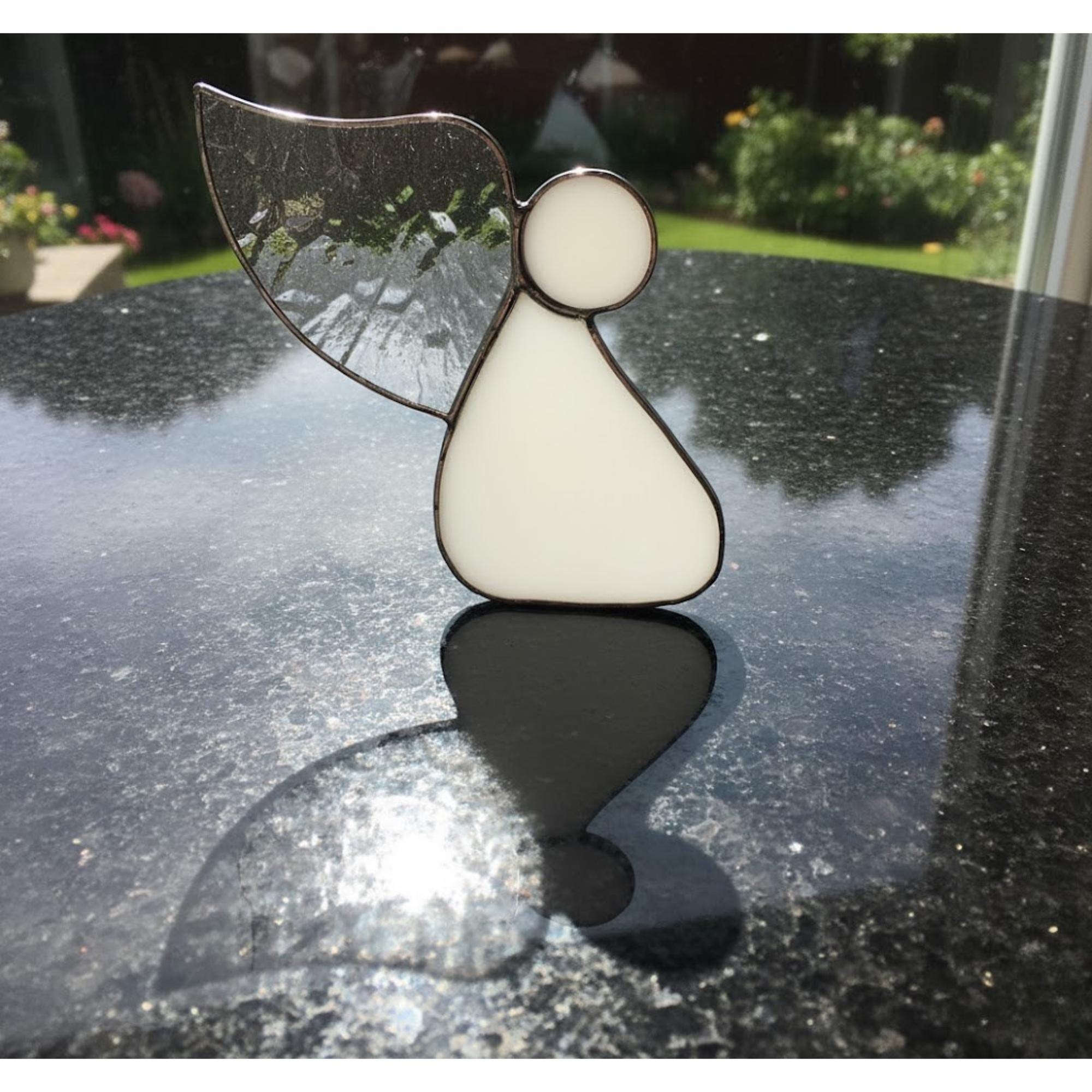 Guardian angel ornament hanging in bright home interior symbolizing peace and love.