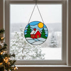Handmade stained glass cottage glowing in living room window, peaceful winter home decoration.
