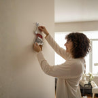 Woman placing stained glass Christmas cat ornament on wall, handmade holiday decoration perfect gift for cat lovers