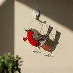 Bedroom window with robin suncatcher, soft morning light home styling