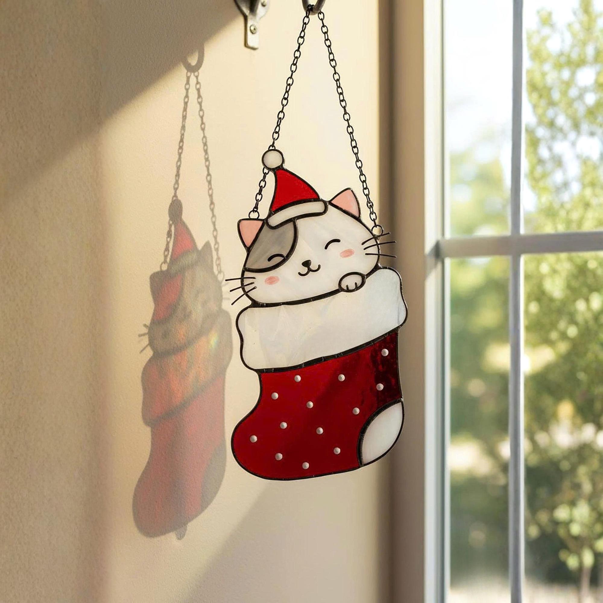 Window view with stained glass cats in stockings glowing in sunlight, festive home decoration.