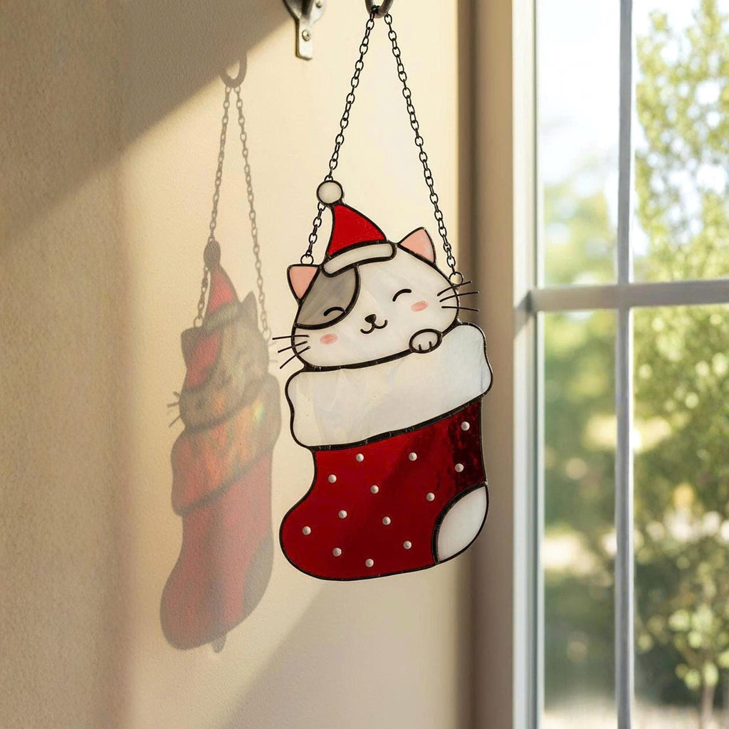 Window view with stained glass cats in stockings glowing in sunlight, festive home decoration.
