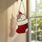 Window view with stained glass cats in stockings glowing in sunlight, festive home decoration.