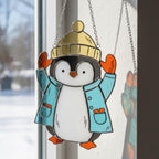 Cute penguin in yellow hat and red scarf, handmade stained glass holiday window ornament.