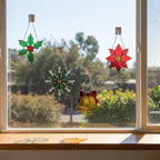 Window with green snowflake and red star ornaments, festive home styling