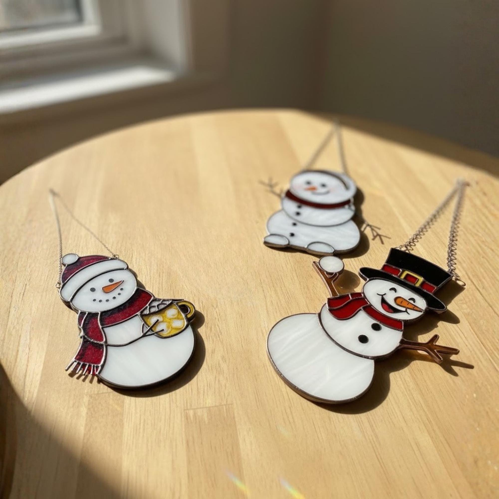 Assorted handmade snowman ornaments on table – winter decoration gift idea.