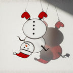 Mini snowman glass ornament hanging in sunlight – cute handmade holiday gift.