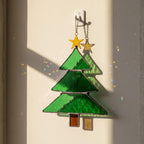 Classic stained glass Christmas tree with star catching sunlight on wall, window ornament