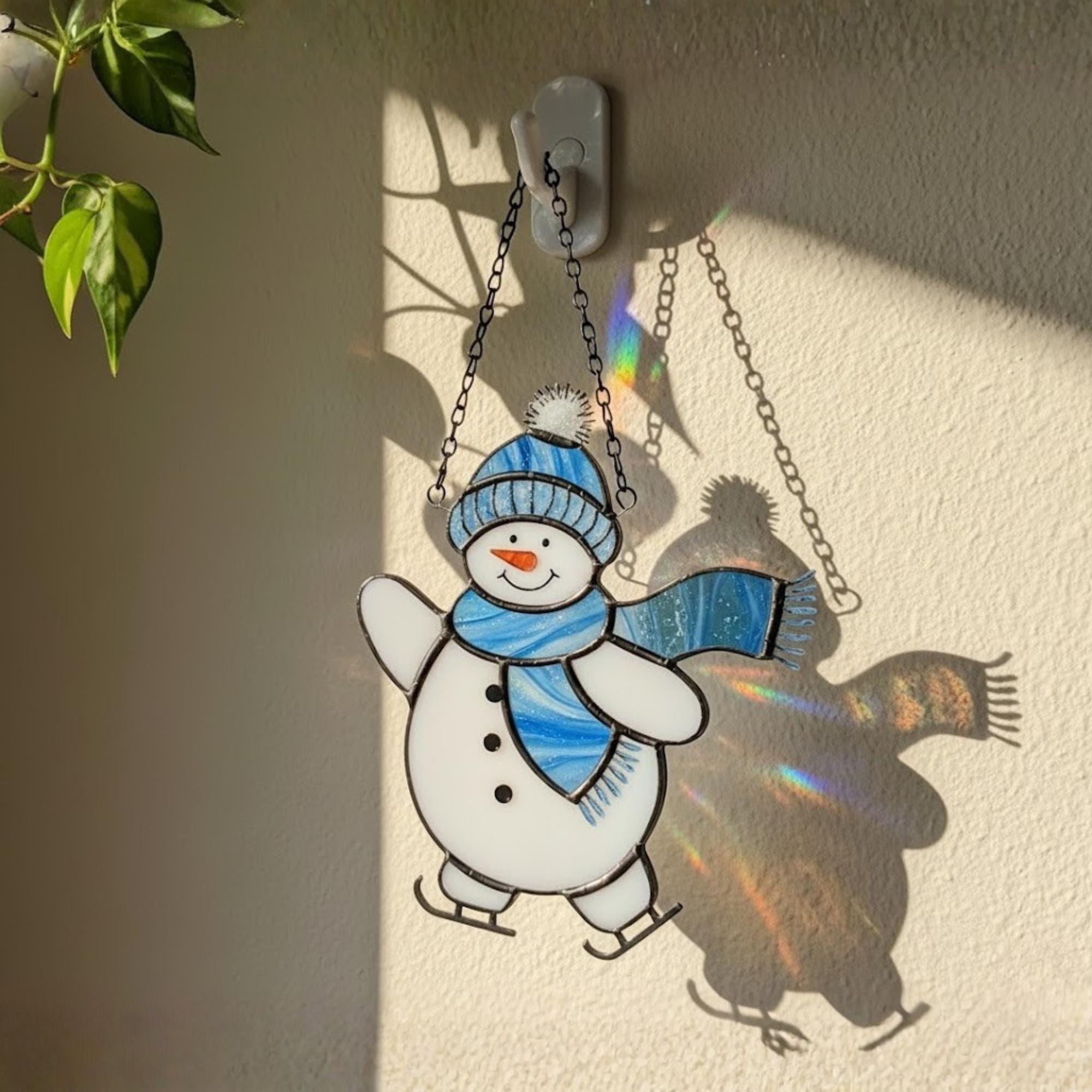 Handmade stained glass snowman ornament hanging in sunlight – winter home decor gift.