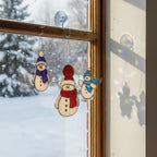 Red snowman glass ornament hanging outdoors – festive handmade Christmas art.