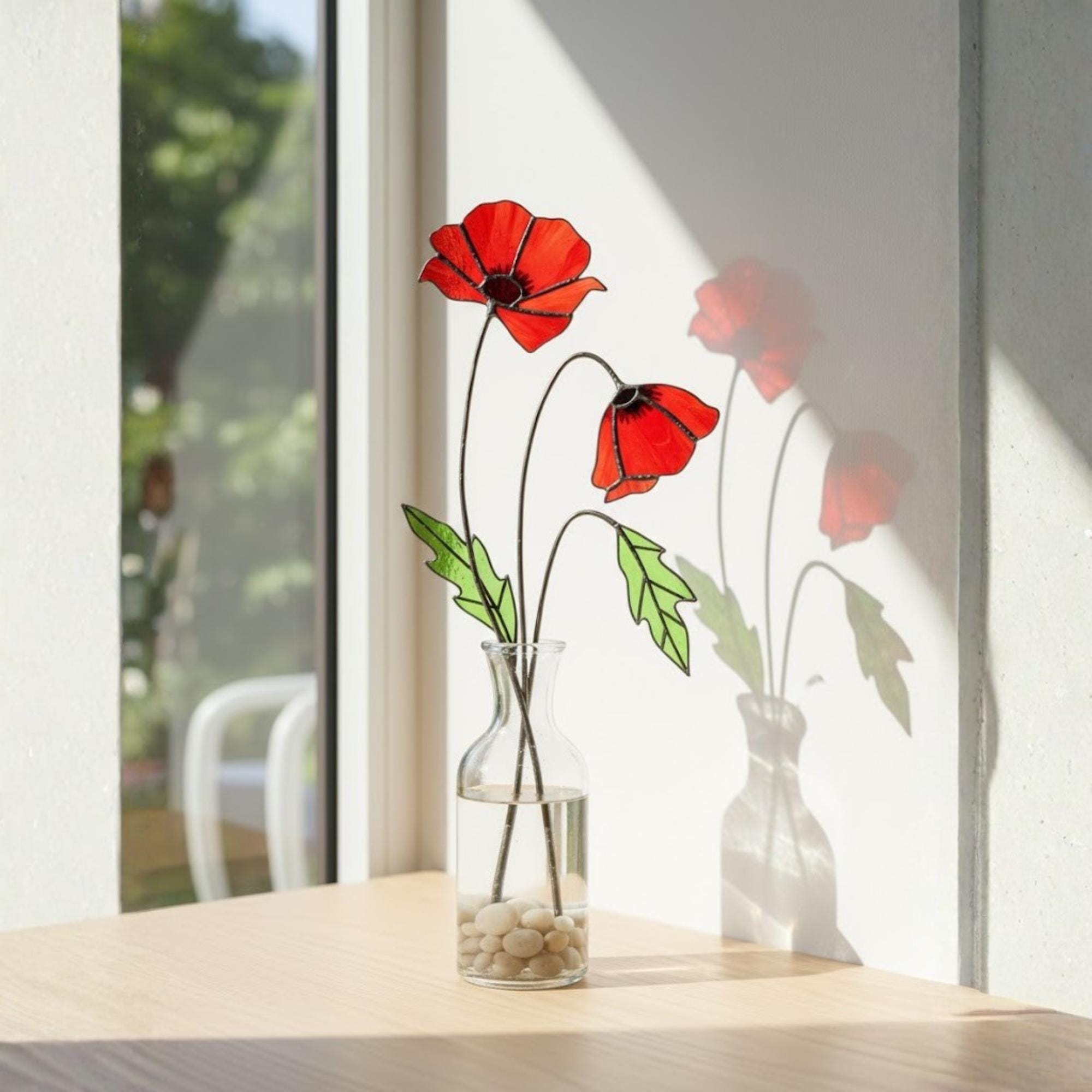 Two stained glass poppy stems displayed on windowsill, handmade floral decor