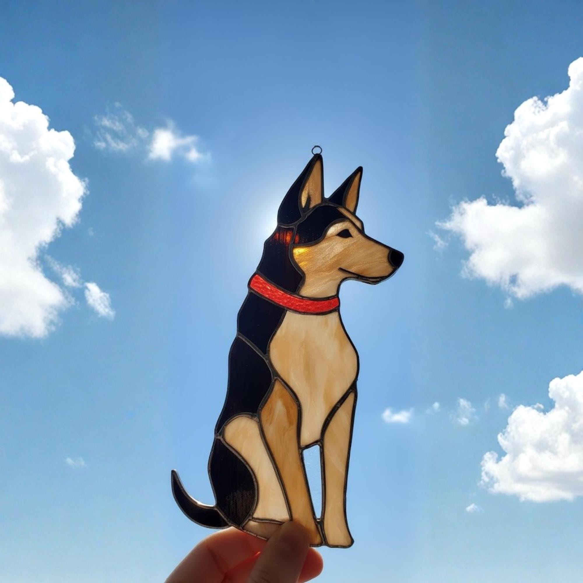 Handmade stained glass German Shepherd dog ornament on windowsill