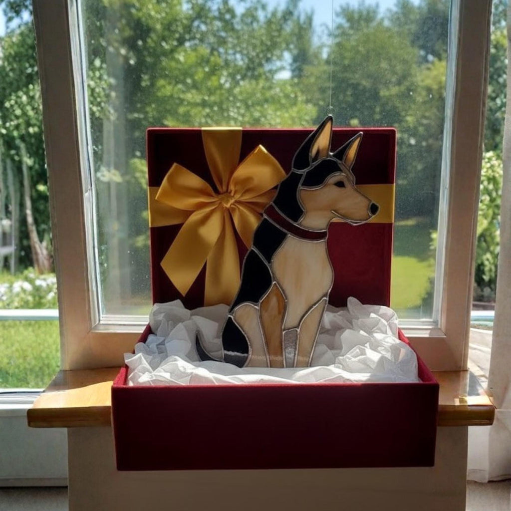 Woman hanging stained glass dog ornament on window, sunlit home decor