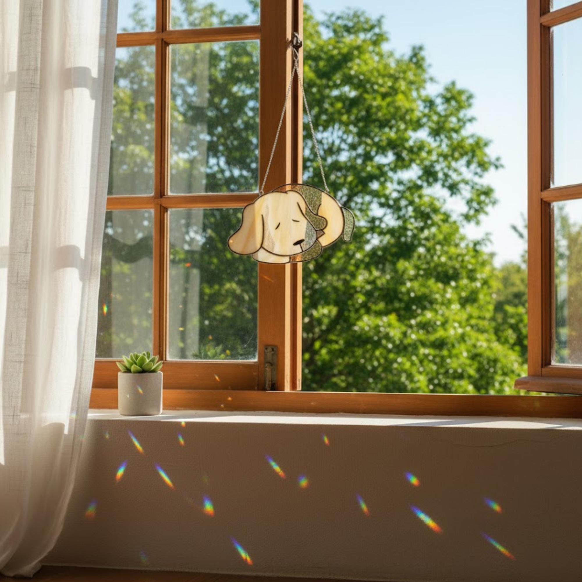 Sleeping dog suncatcher held against blue sky, pet memorial window ornament
