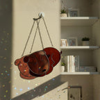 White sleeping dog stained glass ornament glowing in window light