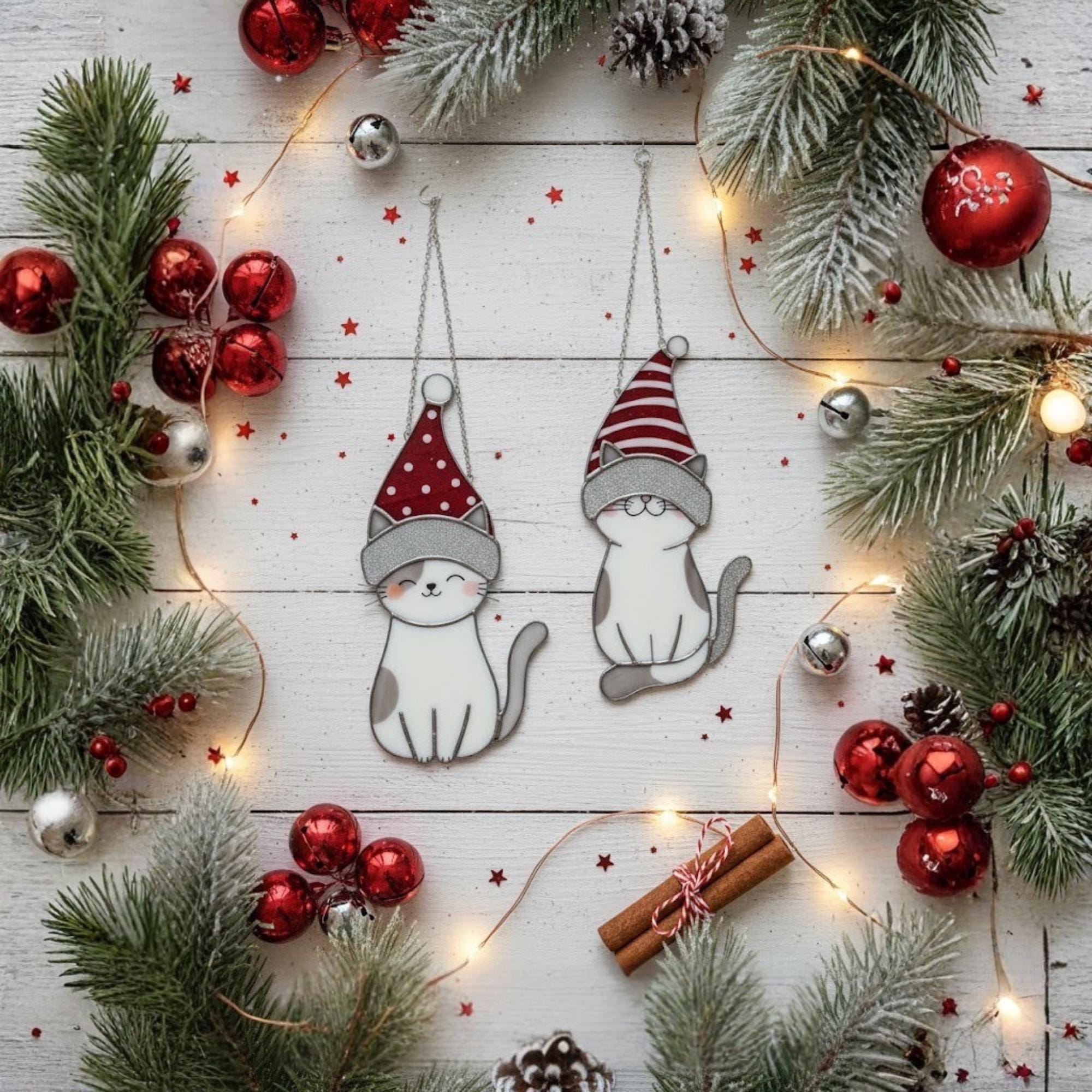 Snow-covered pine branch holding cat glass ornaments – handmade winter suncatcher decor.