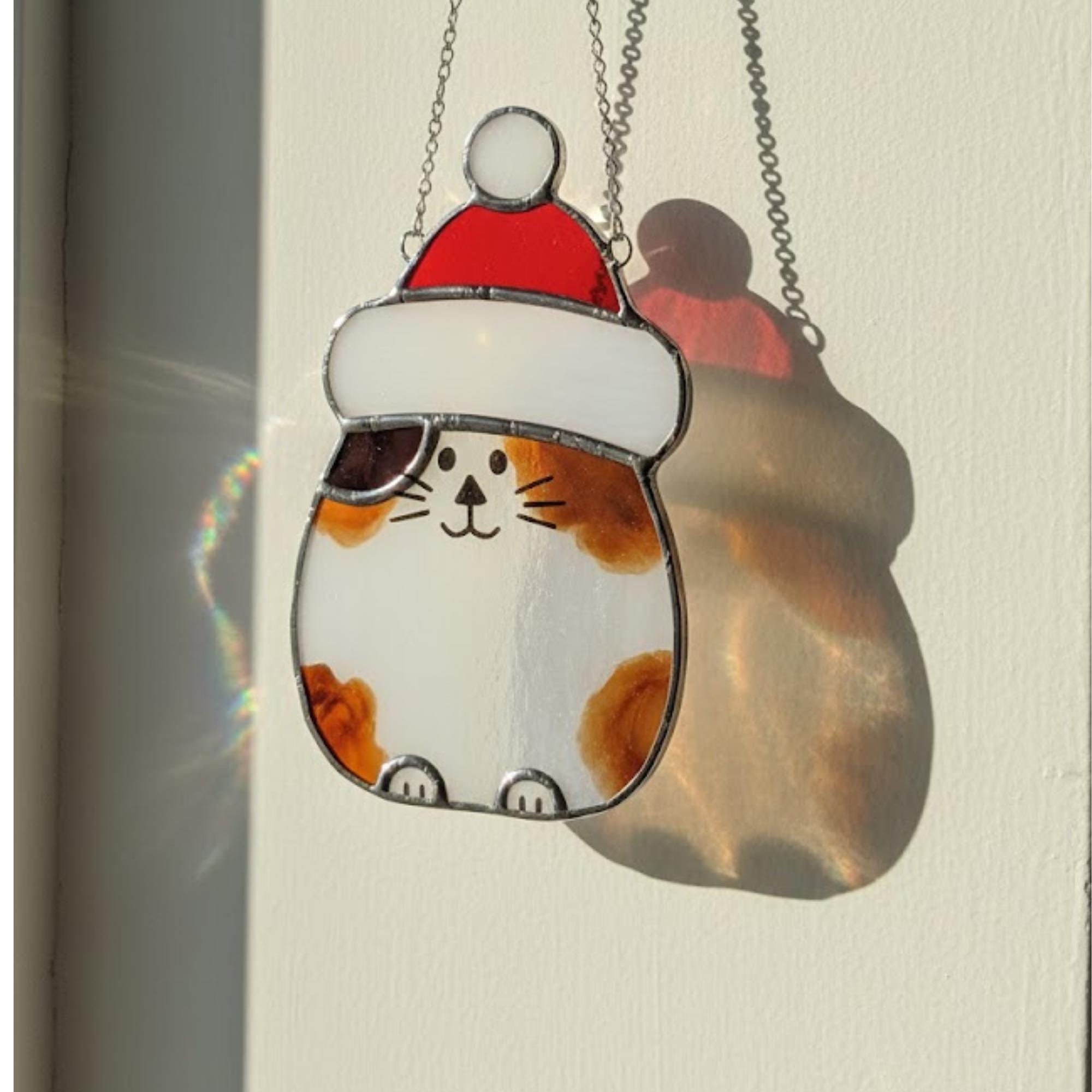 Brown glass cat ornament reflecting sunlight – handmade animal suncatcher decor.