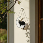 Handmade stained glass cat on the moon suncatcher hanging on tree branch, celestial window decor