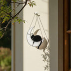Handmade stained glass cat on the moon suncatcher hanging on tree branch, celestial window decor