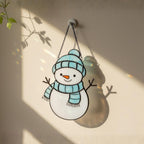 Handmade glass snowman suncatchers displayed on wall – charming Christmas home decor idea.