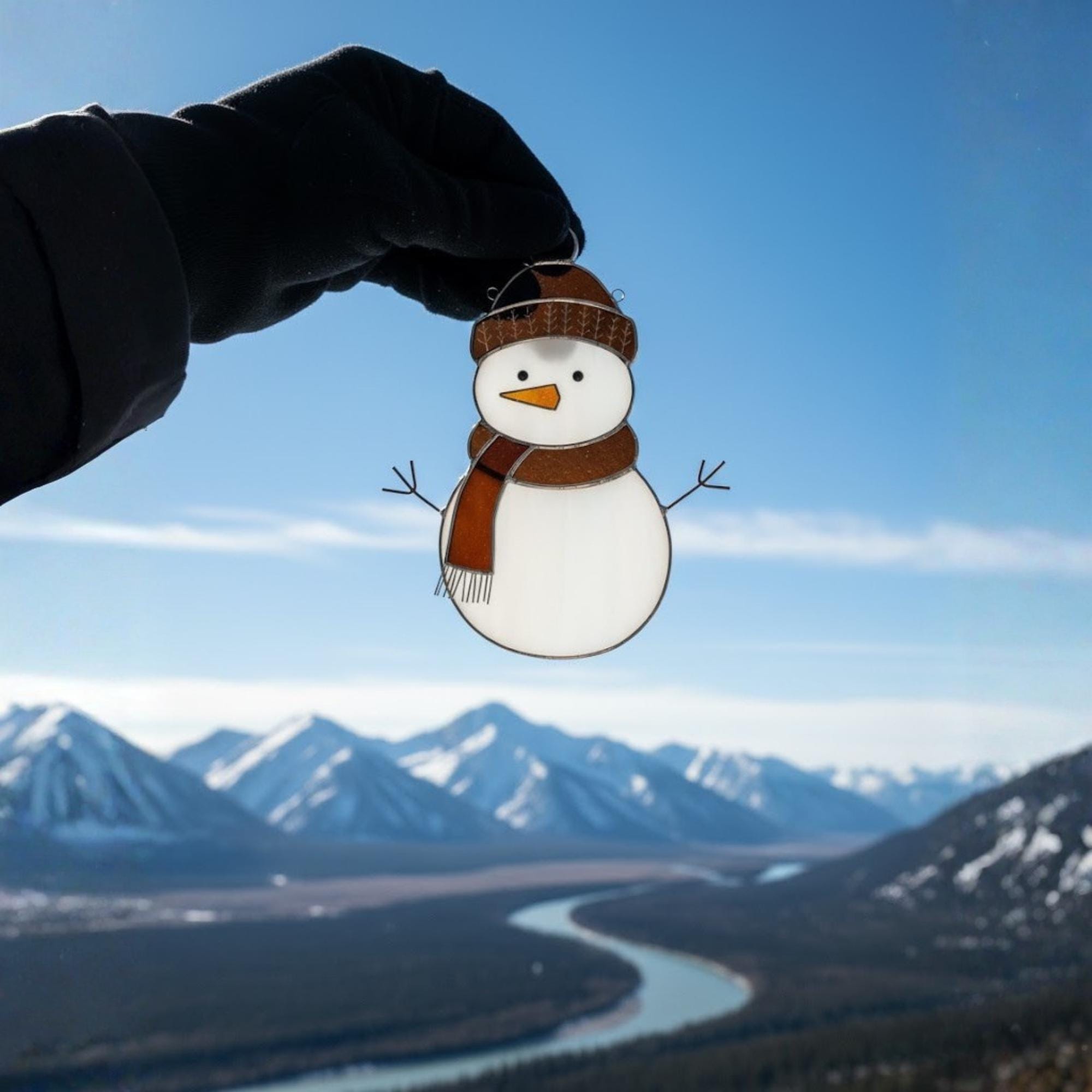 Set of snowman suncatchers hanging near window – colorful handmade glass winter ornament.