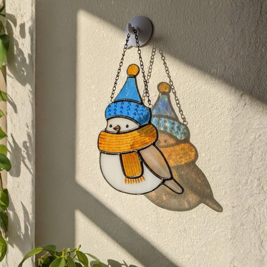 Trio of bird stained glass ornaments casting shadow – cozy handmade glass window decor.